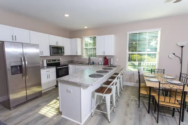 Large open kitchen with a bright window and stainless steel appliances