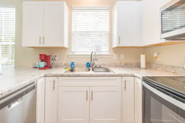 Kitchen counter with a sink under the window and a dishwasher
