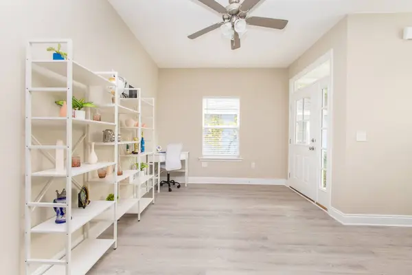 Bright open living space with shelving and a desk