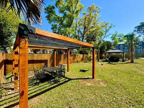 Large pergola over a seating area in the shared backyard