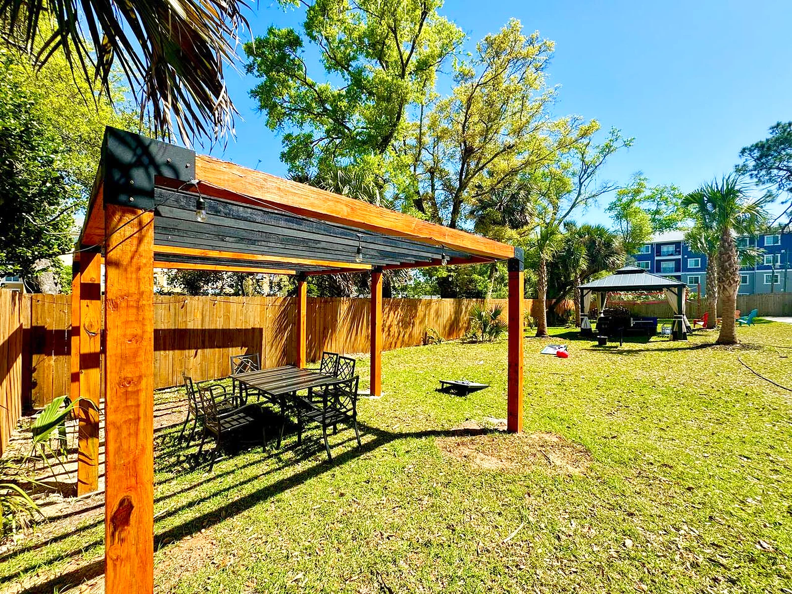 Large pergola over a seating area in the shared backyard