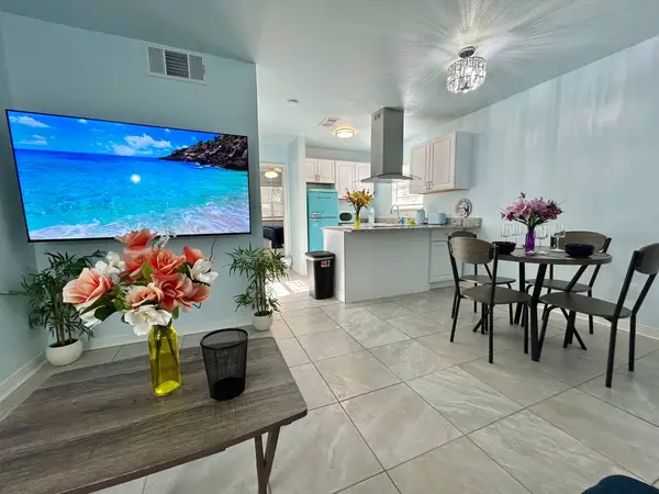 Open living, dining and kitchen area with a large TV