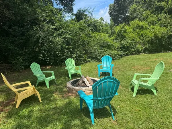 Fire pit with colourful chairs on the shared lawn