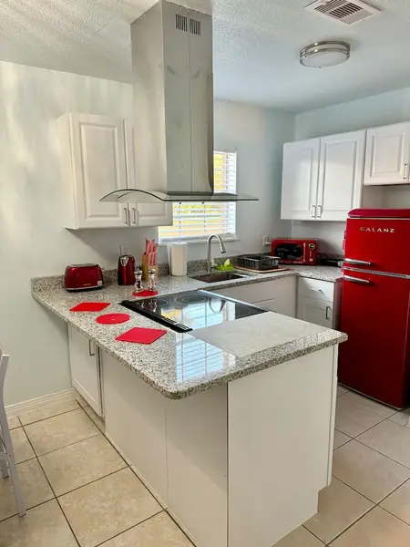 Kitchen counter with a cooktop and retro red appliances