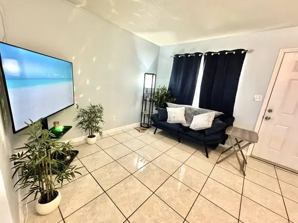 Living area with a large TV and a sofa
