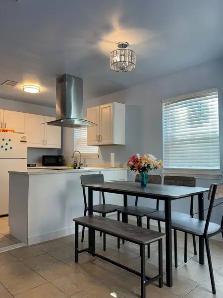 Open kitchen and dining area with a range hood