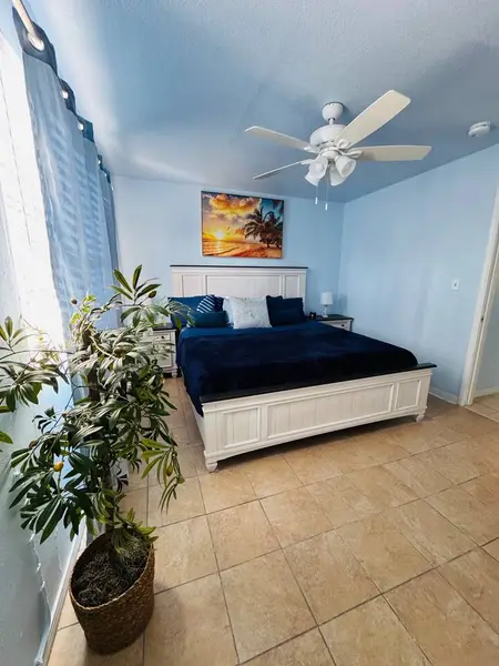 Bedroom with a king bed and a ceiling fan