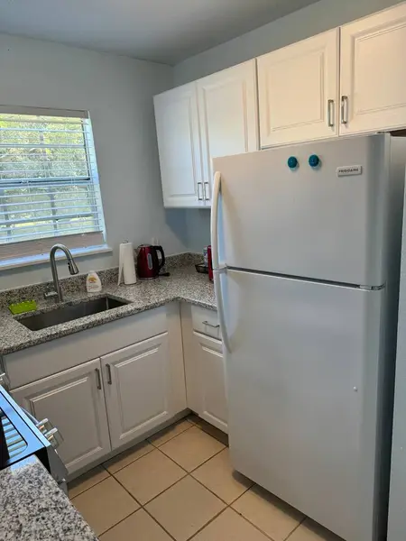 Kitchen with a fridge and sink under the window
