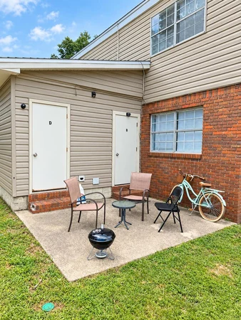 Back patio with chairs, a bistro table, a grill and a bicycle
