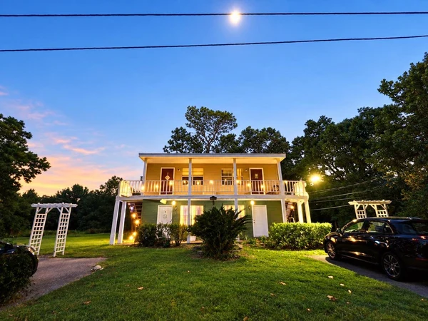 The building at dusk with the porch lights on