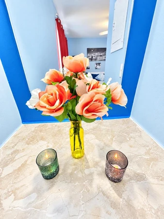 Silk roses and candles on the vanity against a blue wall