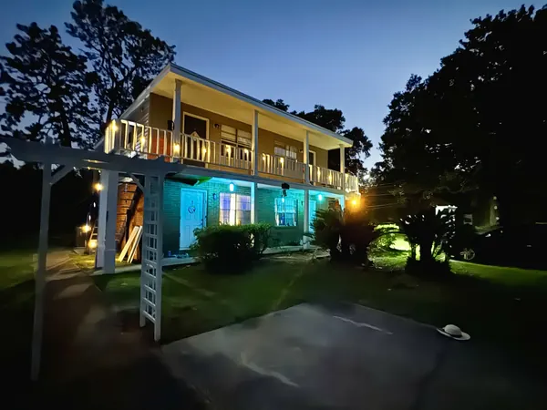 The two-story building lit at dusk, seen from the arbor walkway