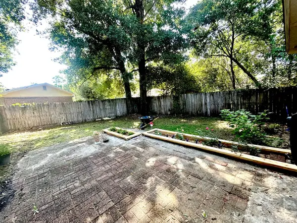 Fully fenced backyard with mature shade trees