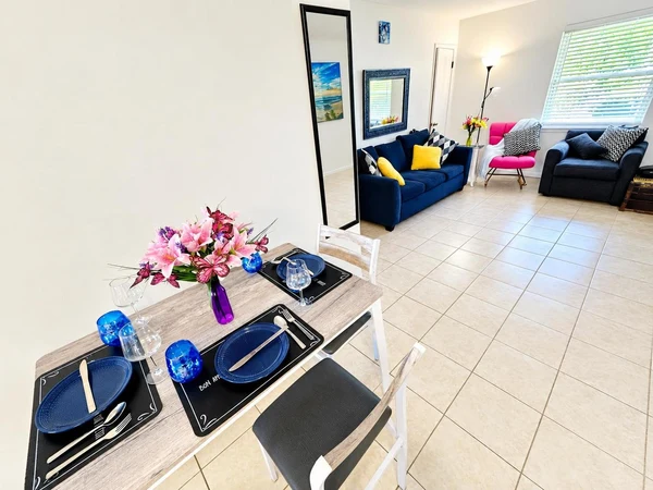 Dining table set for two with the living room beyond
