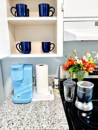 Coffee corner with a Keurig, blender and blue mugs on granite counters