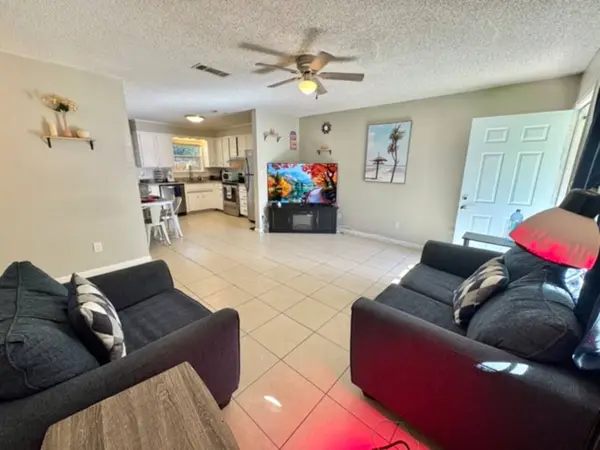 Open living area with two sofas and the kitchen behind