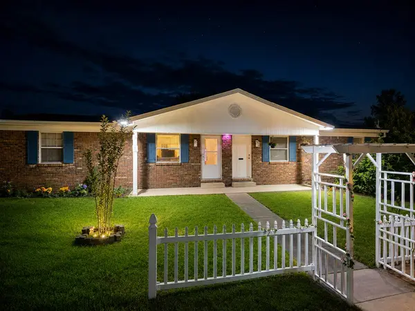 Front of the duplex at dusk with a fenced lawn