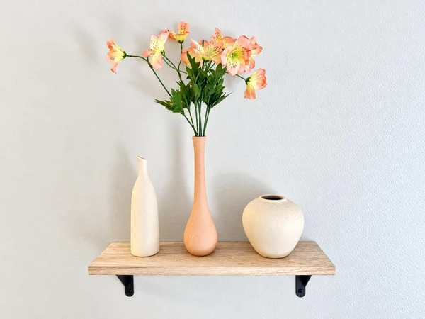 Wall shelf with vases and faux flowers