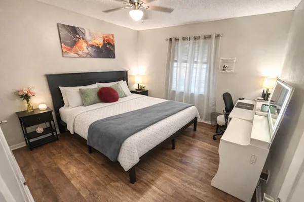 Bedroom with a queen bed, matching nightstands and a desk workstation